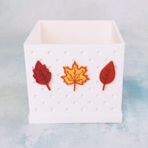red yellow orange fall leaves on white snappy pot